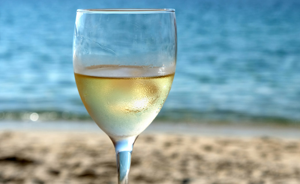Copa de Vino blanco con el mar mediterráneo de fondo