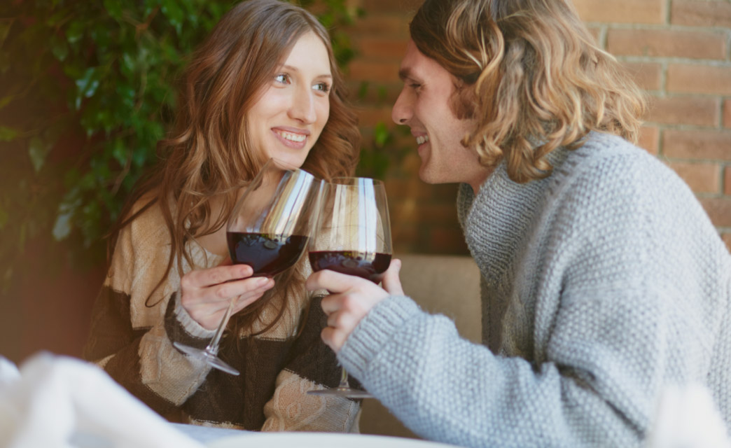 Pareja brindando con Vino Tinto