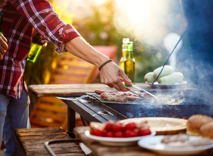 Person, die Fleisch auf einem Grill kocht