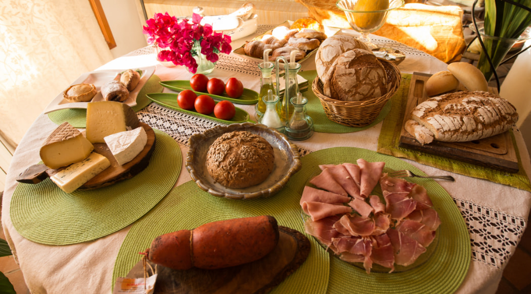 Charcutería, queso y pan servidos en una mesa