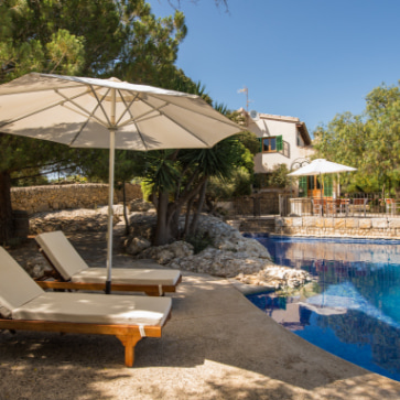 Outdoor swimming pool with sunbeds and umbrella