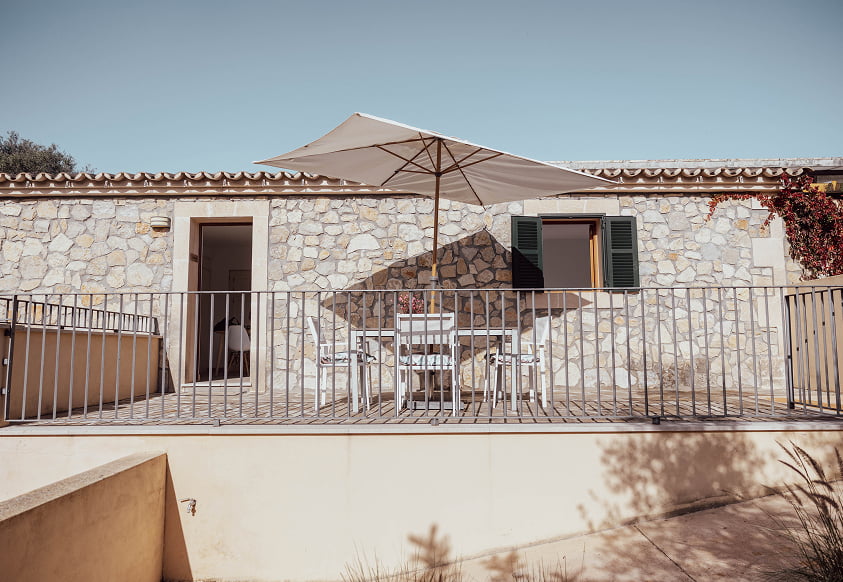 Außenterrasse mit Tisch, Stühlen und Sonnenschirm