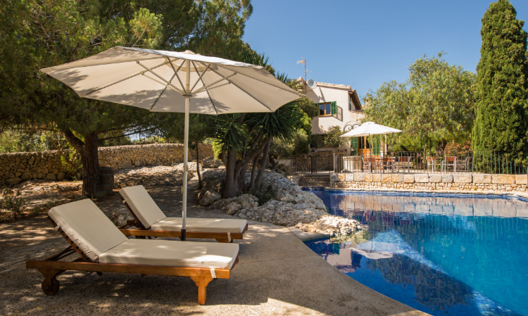 Hammocks, umbrella and swimming pool at Can Feliu