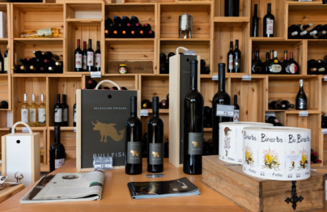 Shelf and table full of wine bottles